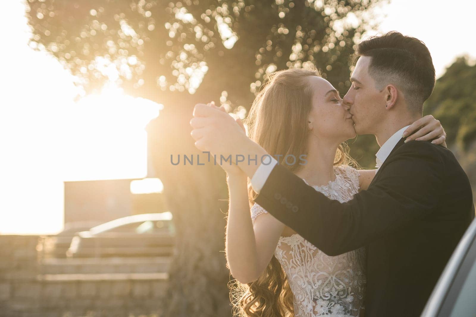 Bride and groom standing in golden sunlight after ceremony. Joy, new beginnings and emotional connection on a wedding day