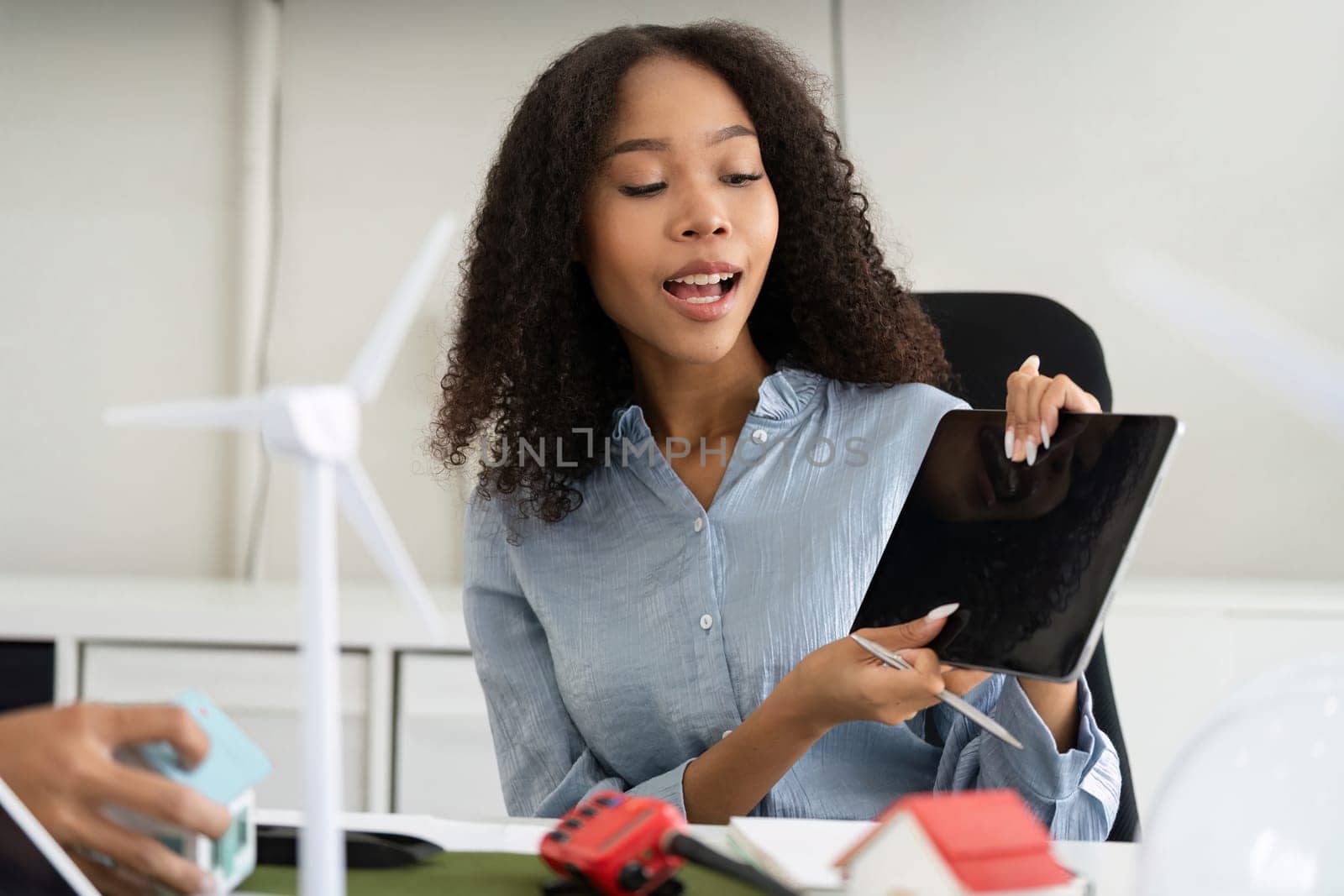 In a dynamic work environment, a dedicated professional engages her audience with creative sustainable project concepts, showcasing innovative practices for a greener future.
