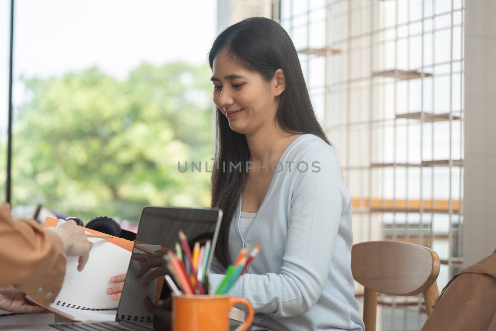 A happy student enjoys a productive study session, exchanging notes and ideas with a friend, fostering an engaging learning environment.