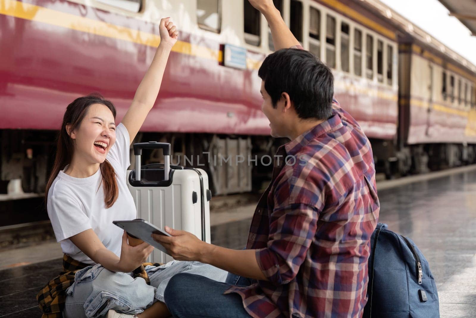 Excited about their upcoming journey, a young couple shares joyous moments at the train station, expressing their love for travel and each other.