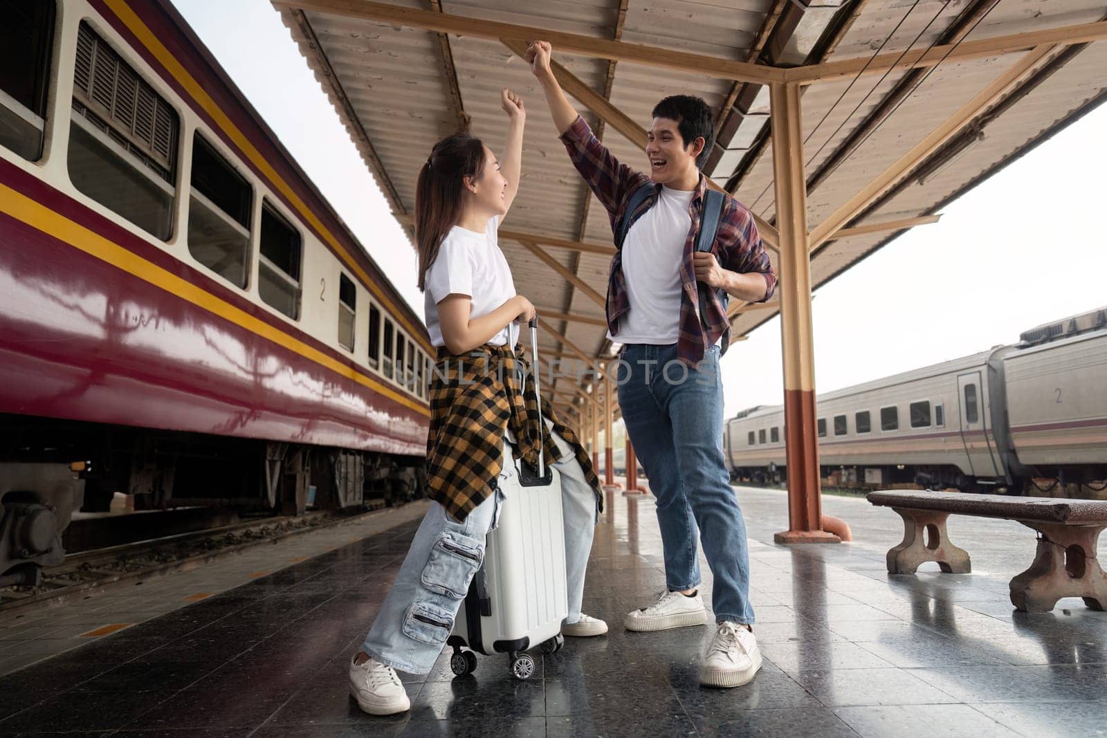 Following their travel planning session, the couple exudes joy and excitement at the train station, embodying a true spirit of adventure.