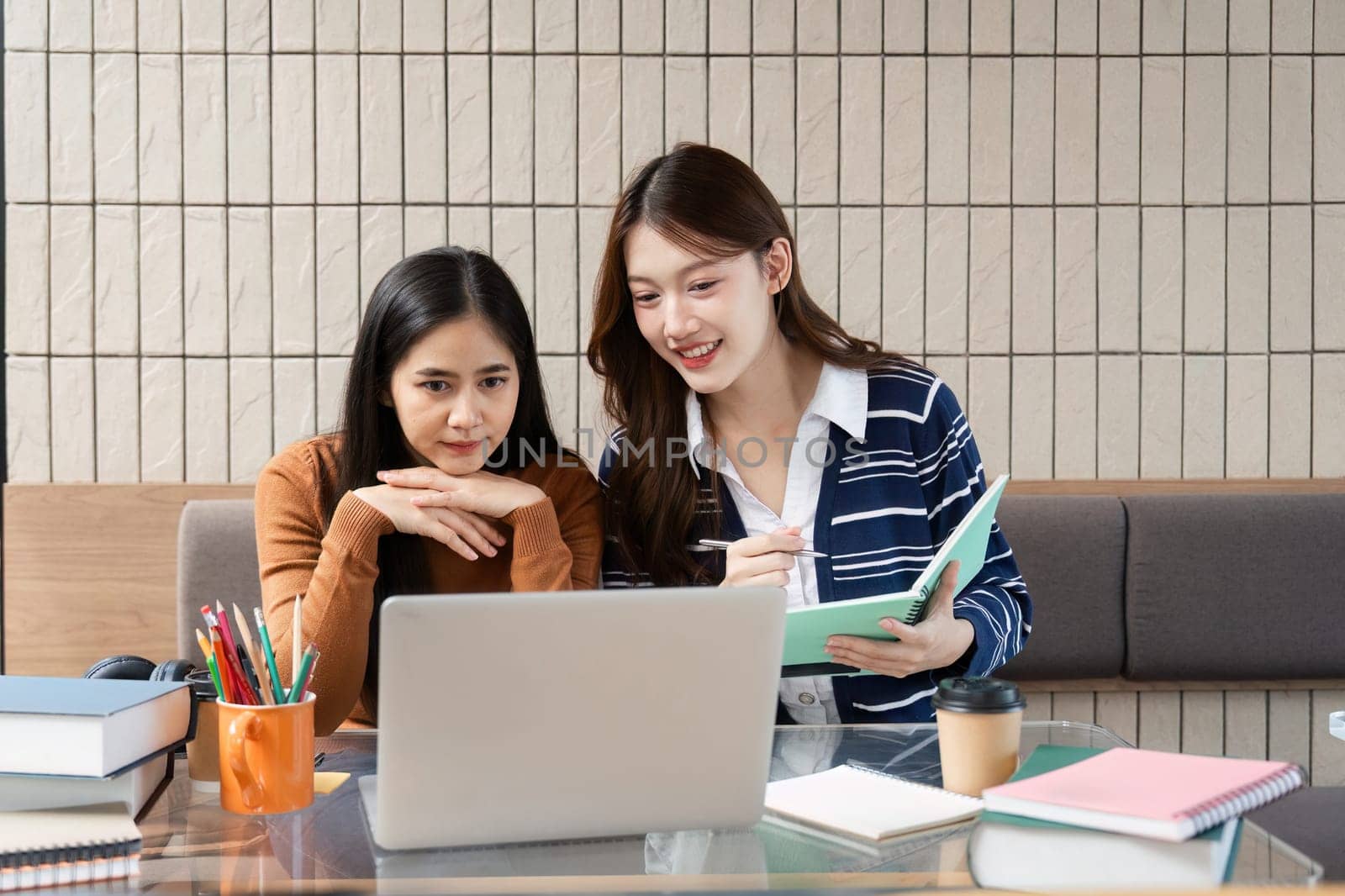 Friends support each other while examining their notes and discussing project topics, creating an inviting environment for learning and collaboration.