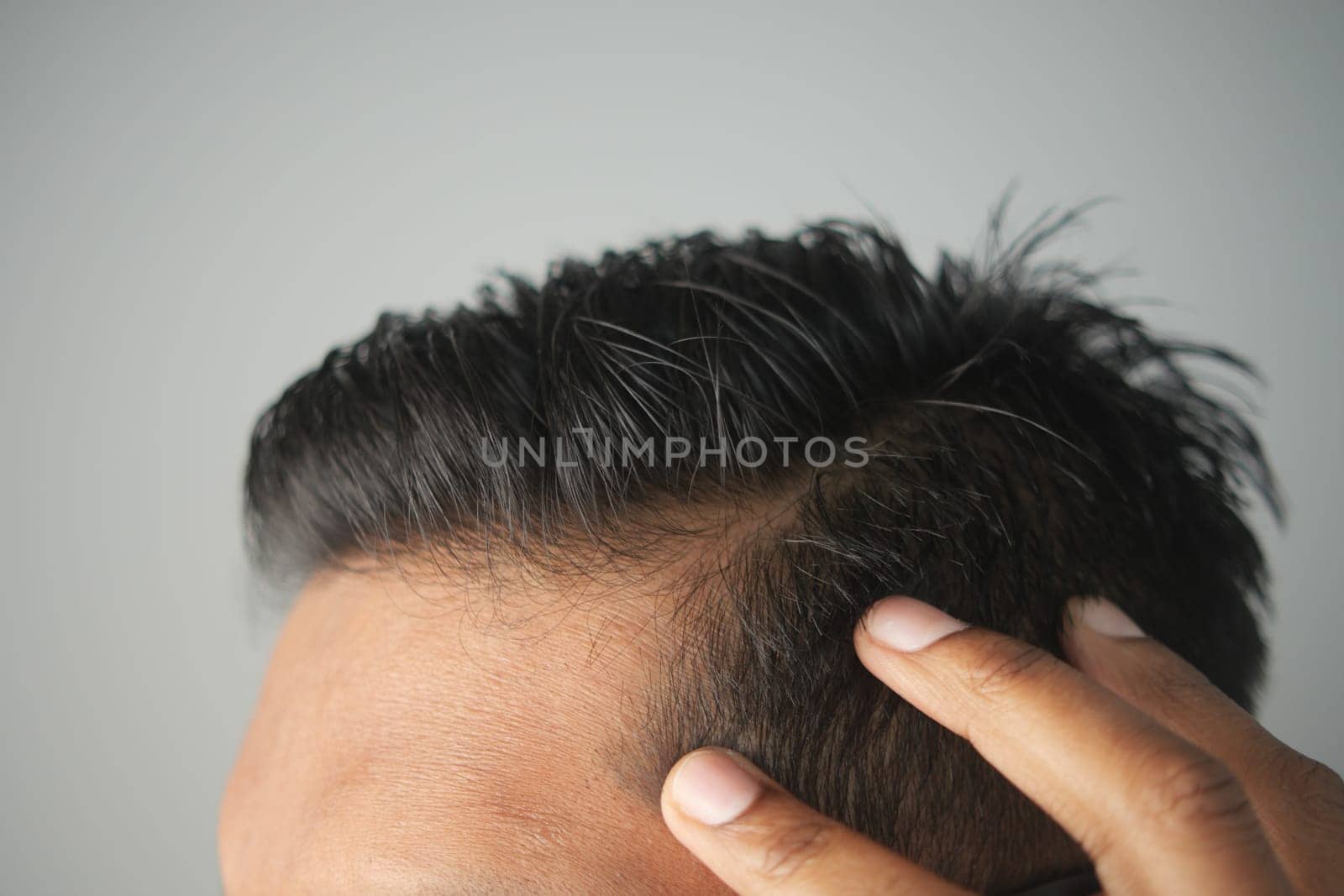 Close-up of a person adjusting their hair for a fresh, neat look.