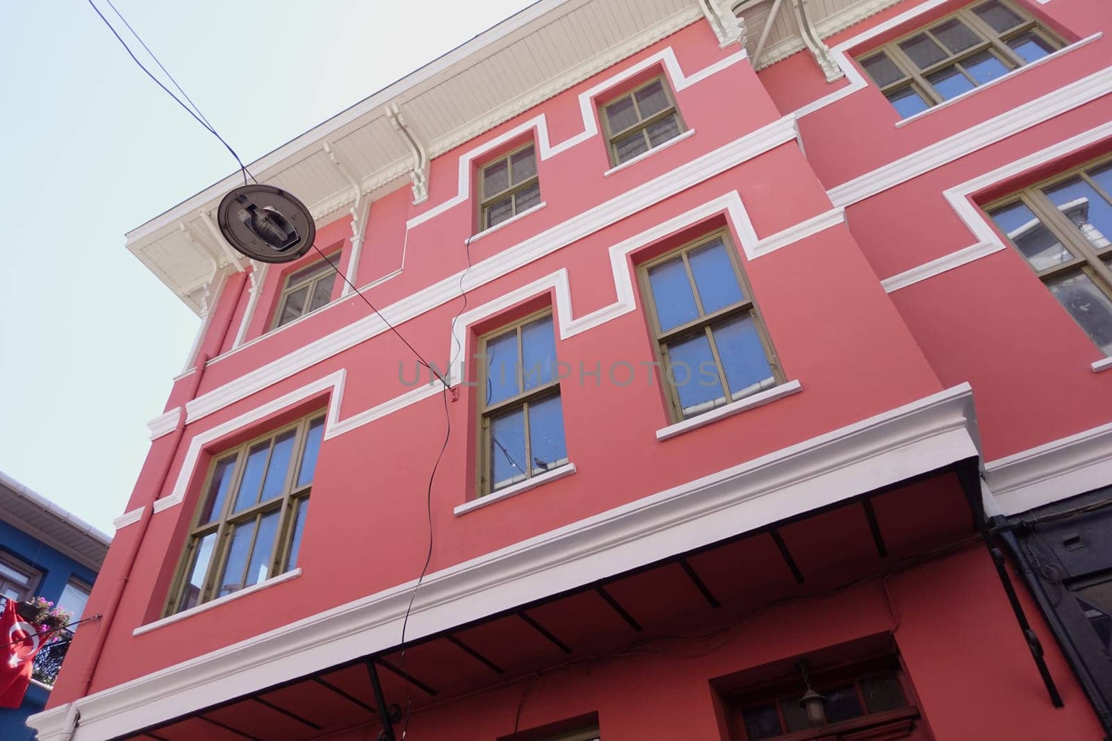 A colorful building features several windows against a bright sky.