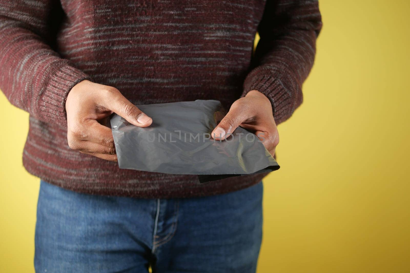 Individual is carefully handling a gray-wrapped package indoors.