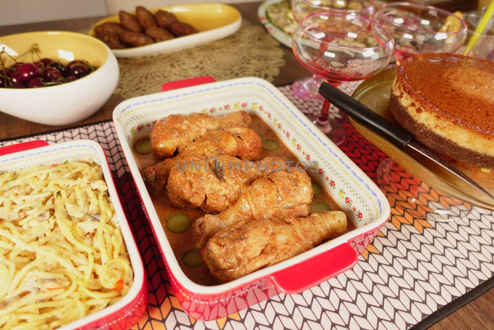 A table is filled with fried chicken, pasta, and cake.