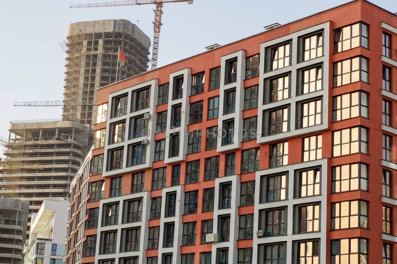 A large modern building, featuring an abundance of windows, is currently in the process of construction, making progress every day