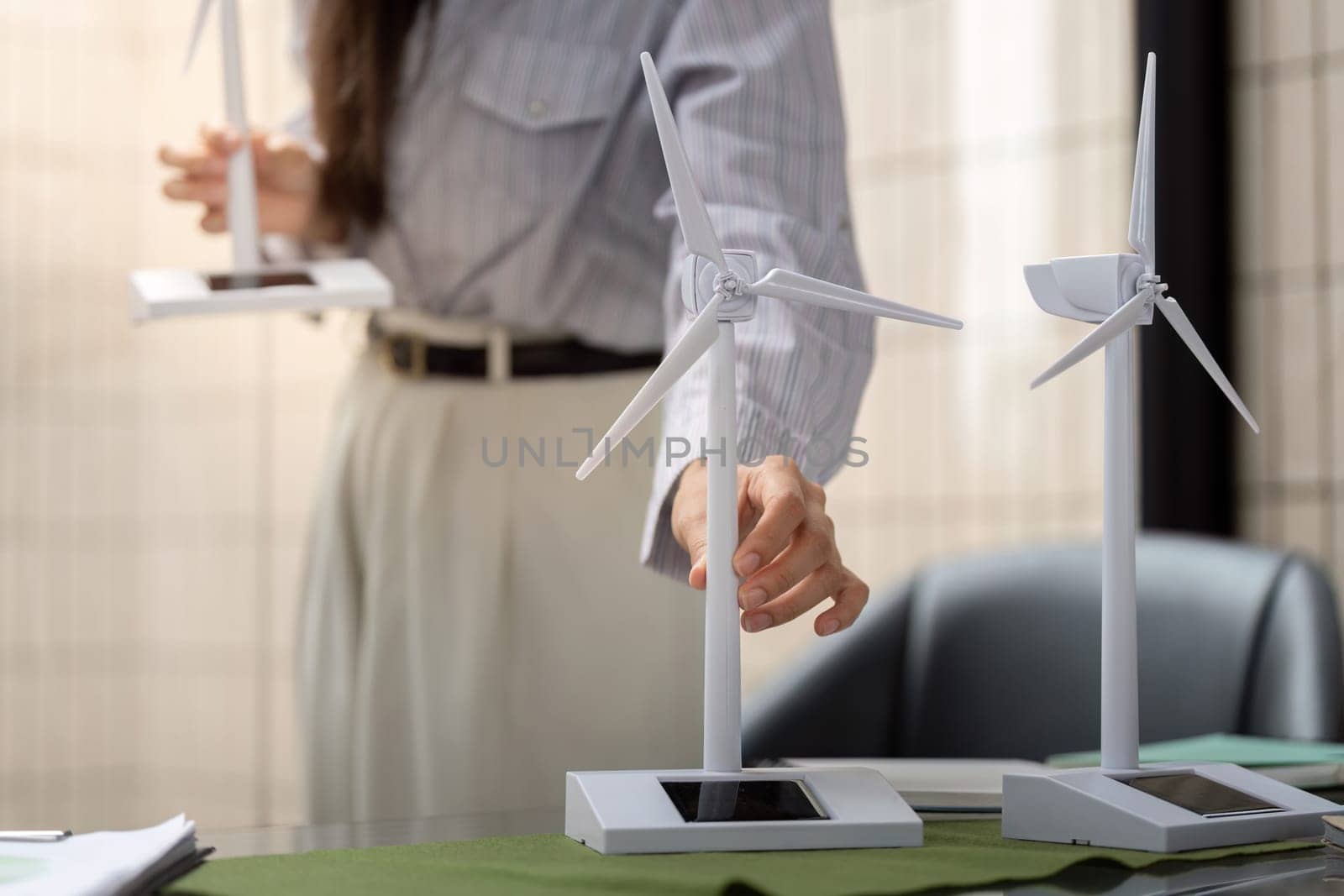 The dedicated professional demonstrates renewable energy models, discussing their significance in achieving ESG objectives with her team.