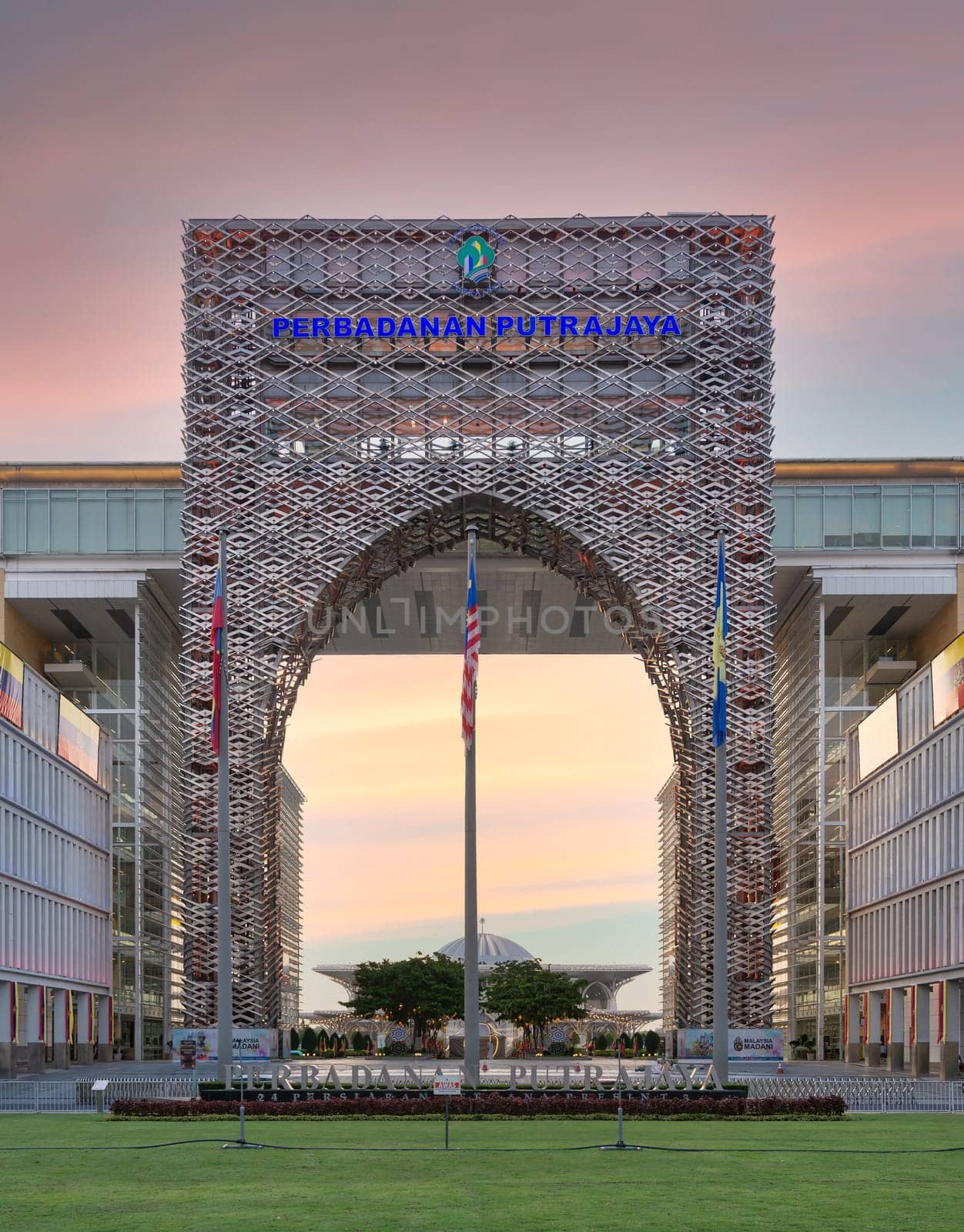 Putrajaya, Malaysia - Feb. 20 2025: The iconic entrance of Perbadanan Putrajaya, stands tall against vibrant sunset. Surrounding greenery and calm atmosphere enhance this architectural marvel's appeal