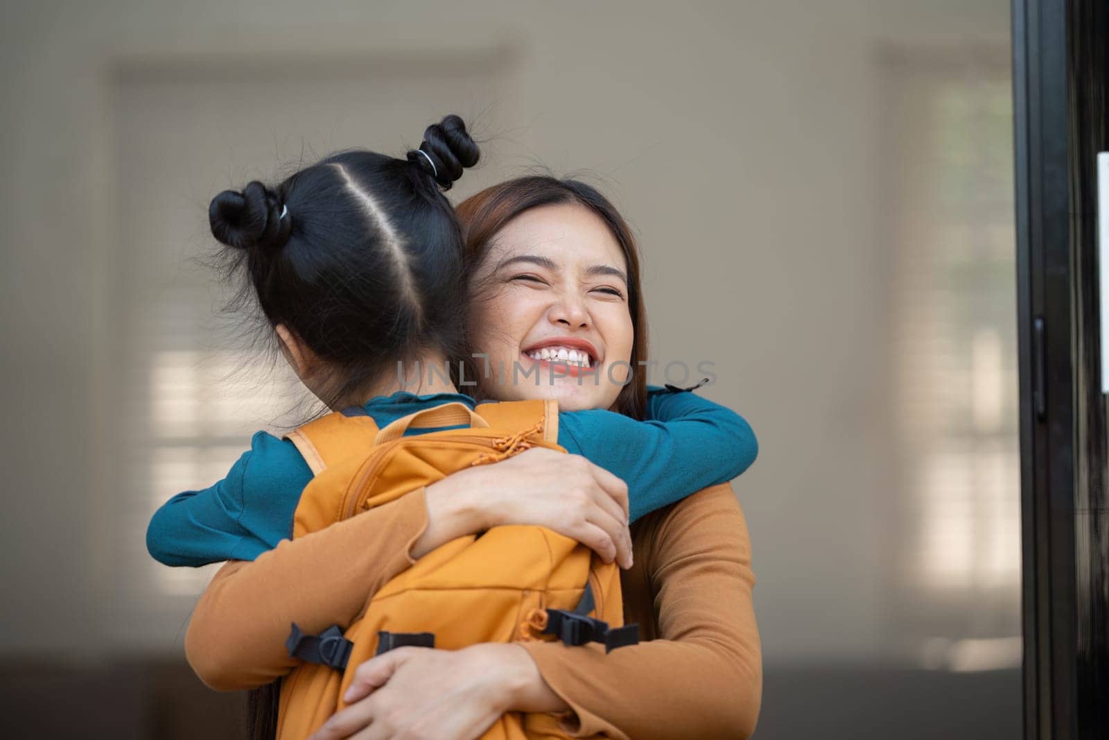A touching moment between a mother and her daughter as they share a joyful hug, emphasizing the strength of their bond and the comfort of home.