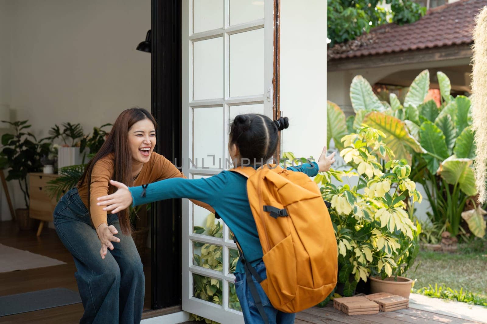 A little girl excitedly greets her mother with a warm hug after returning from school. This moment reflects the deep emotional connection and joy of family reunions.