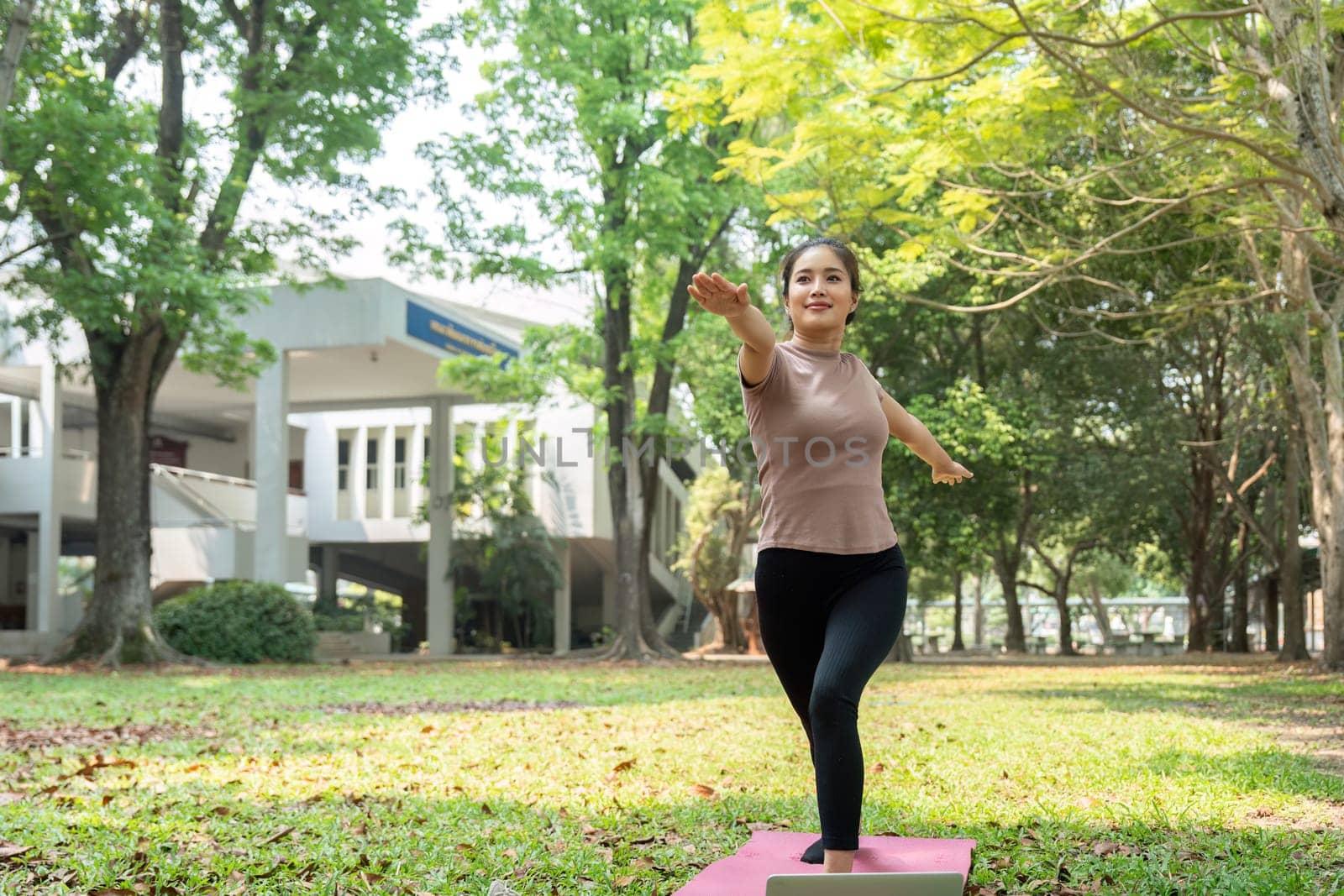 In a peaceful garden, a woman performs yoga, reaching for balance and peace, integrating her daily routine with the beauty of nature.