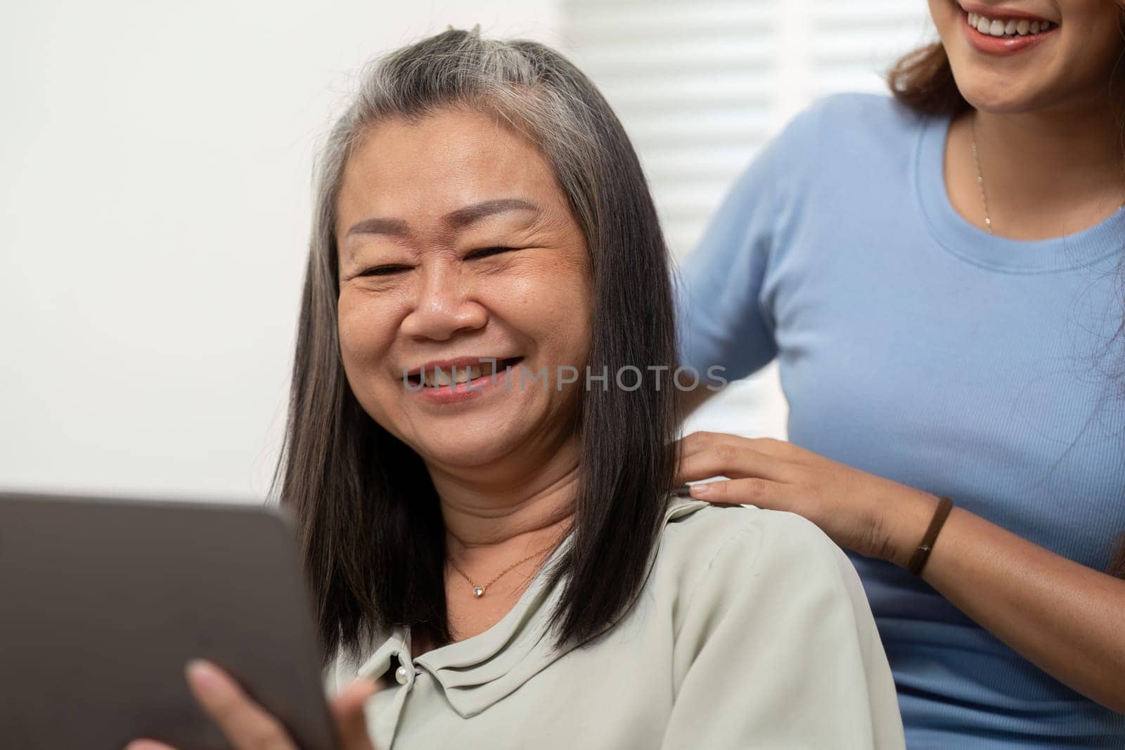 A mother happily engages with her daughter as they explore digital wellness routines together, highlighting their strong bond and modern lifestyle.