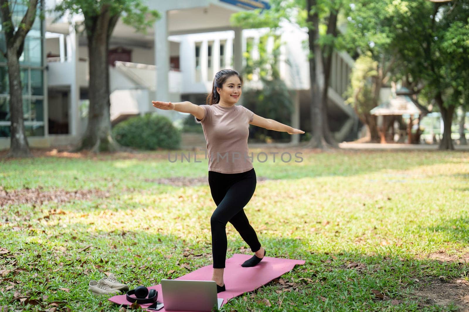 A young woman demonstrates strength and grace while practicing yoga outdoors, connecting mind and body through her fitness routine.