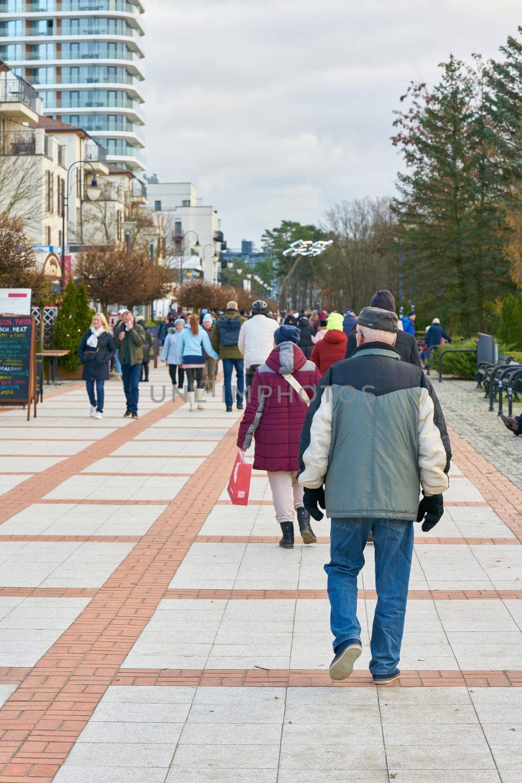 Swinoujscie, Poland – December 24, 2024: Vacationers on the beach promenade, Promenada in Swinoujscie on the Polish Baltic coast