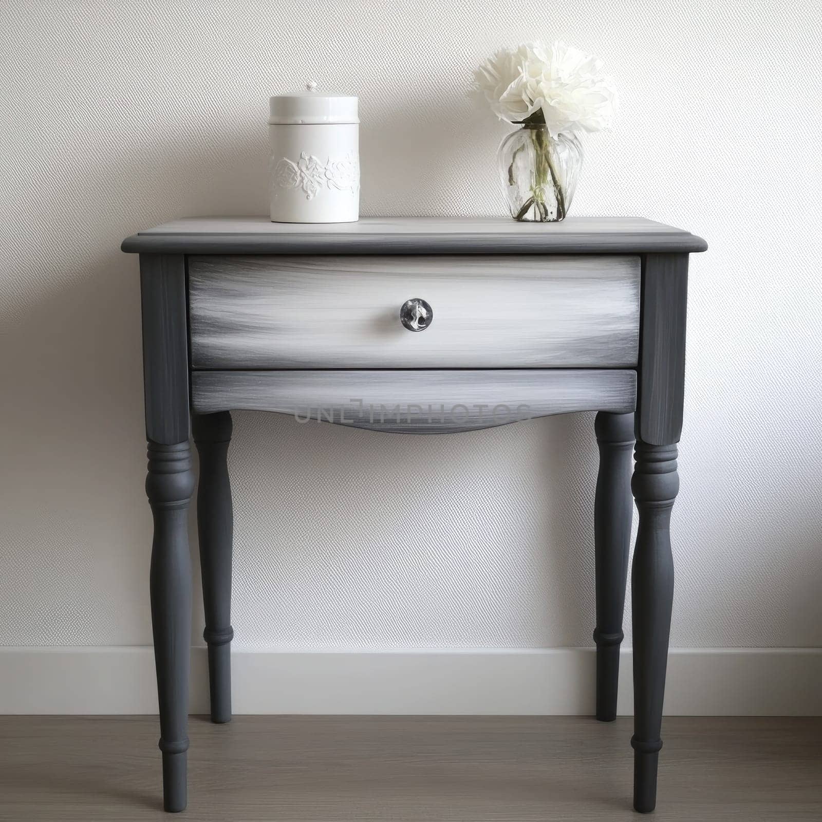 A beautifully painted table showcases a sleek design in a minimalist room. It features a single drawer and is accentuated by a delicate vase and white flower.
