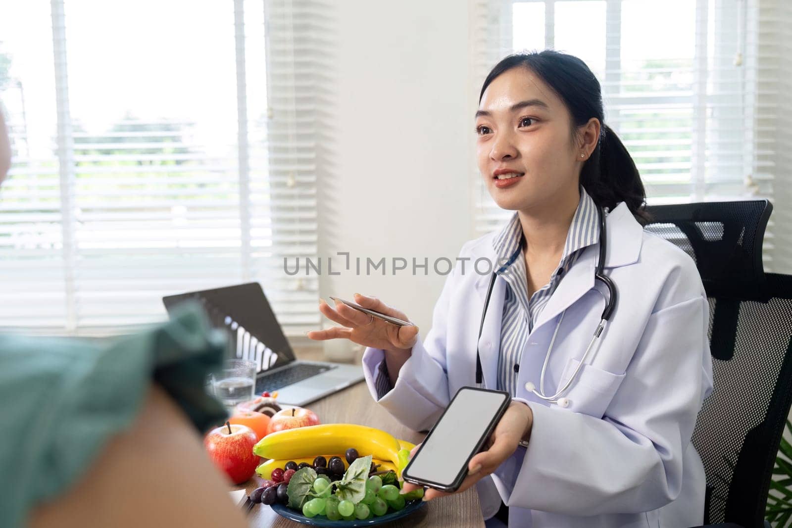 During a nutritional consultation, a healthcare professional explains dietary options using a smartphone, highlighting the importance of technology in promoting wellness.