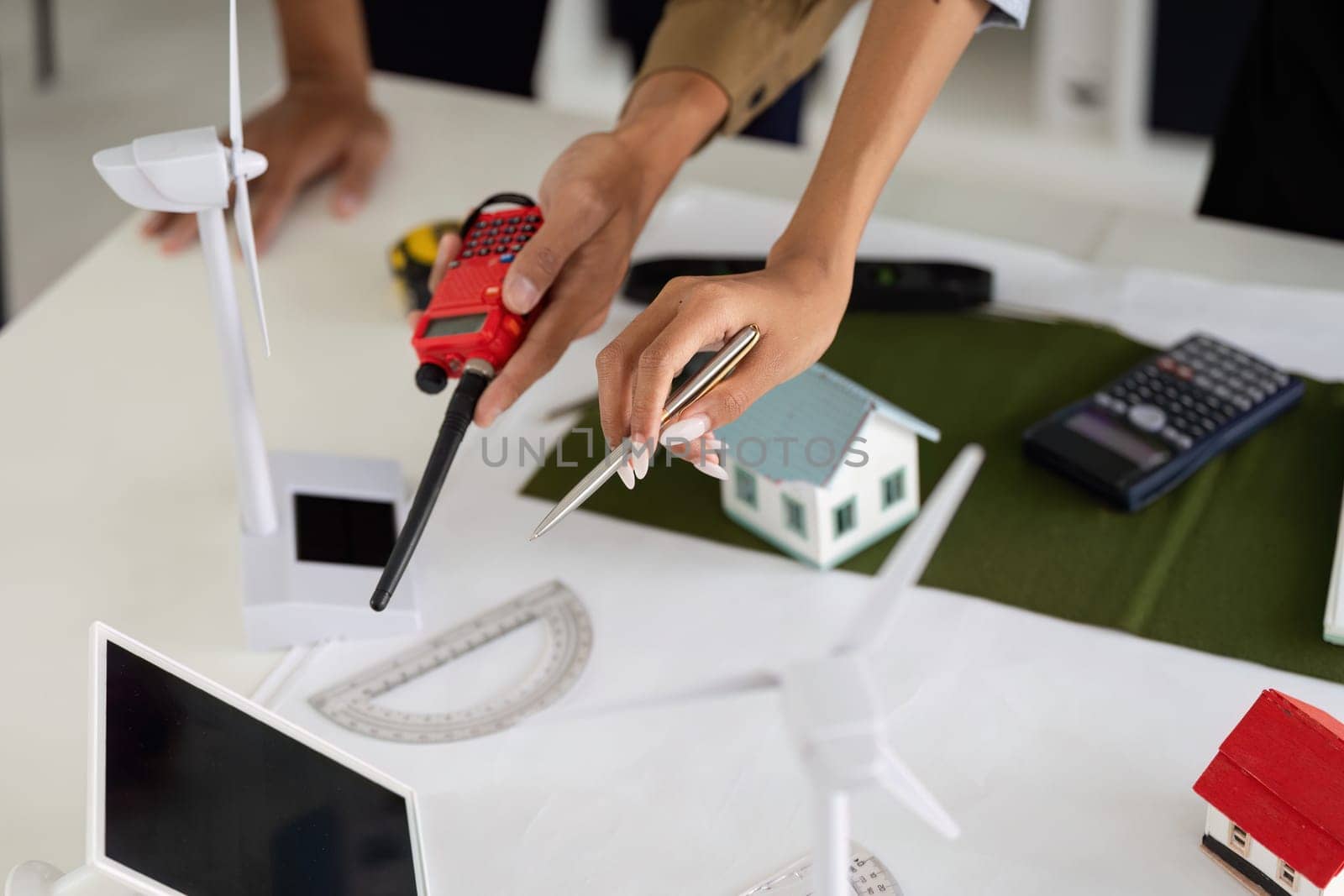 Hands-on collaboration among professionals revolves around creating models of wind turbines and eco-friendly homes, reflecting modern sustainable practices.