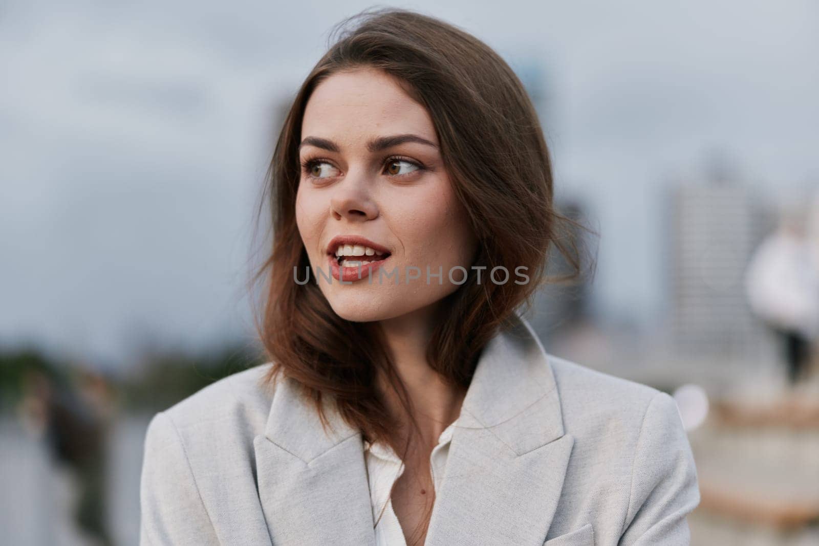 A confident businesswoman with a warm smile in a stylish suit, capturing a contemporary urban environment. This image reflects professionalism, ambition, and empowerment.
