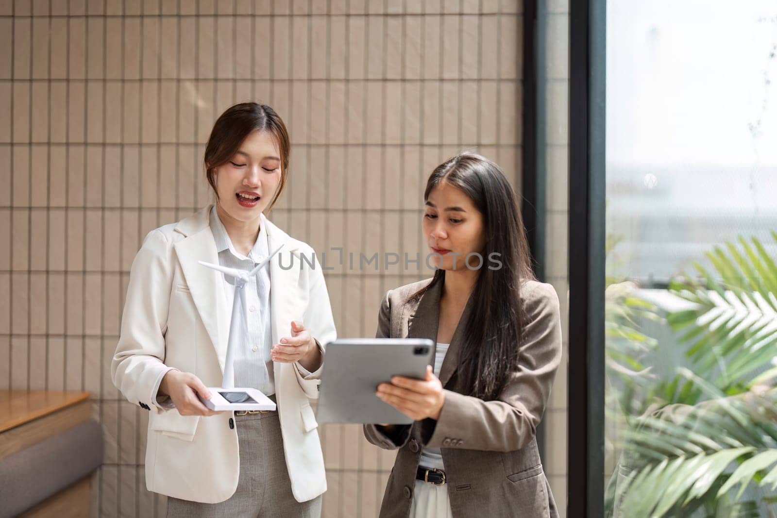 Two businesswomen share ideas on using innovative technologies to support sustainability efforts, focusing on collaboration, networking, and eco-friendly practices in their industry.