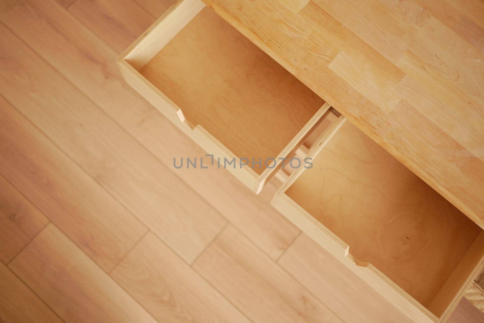 Two wooden drawers remain open in a simple, minimalist interior design.