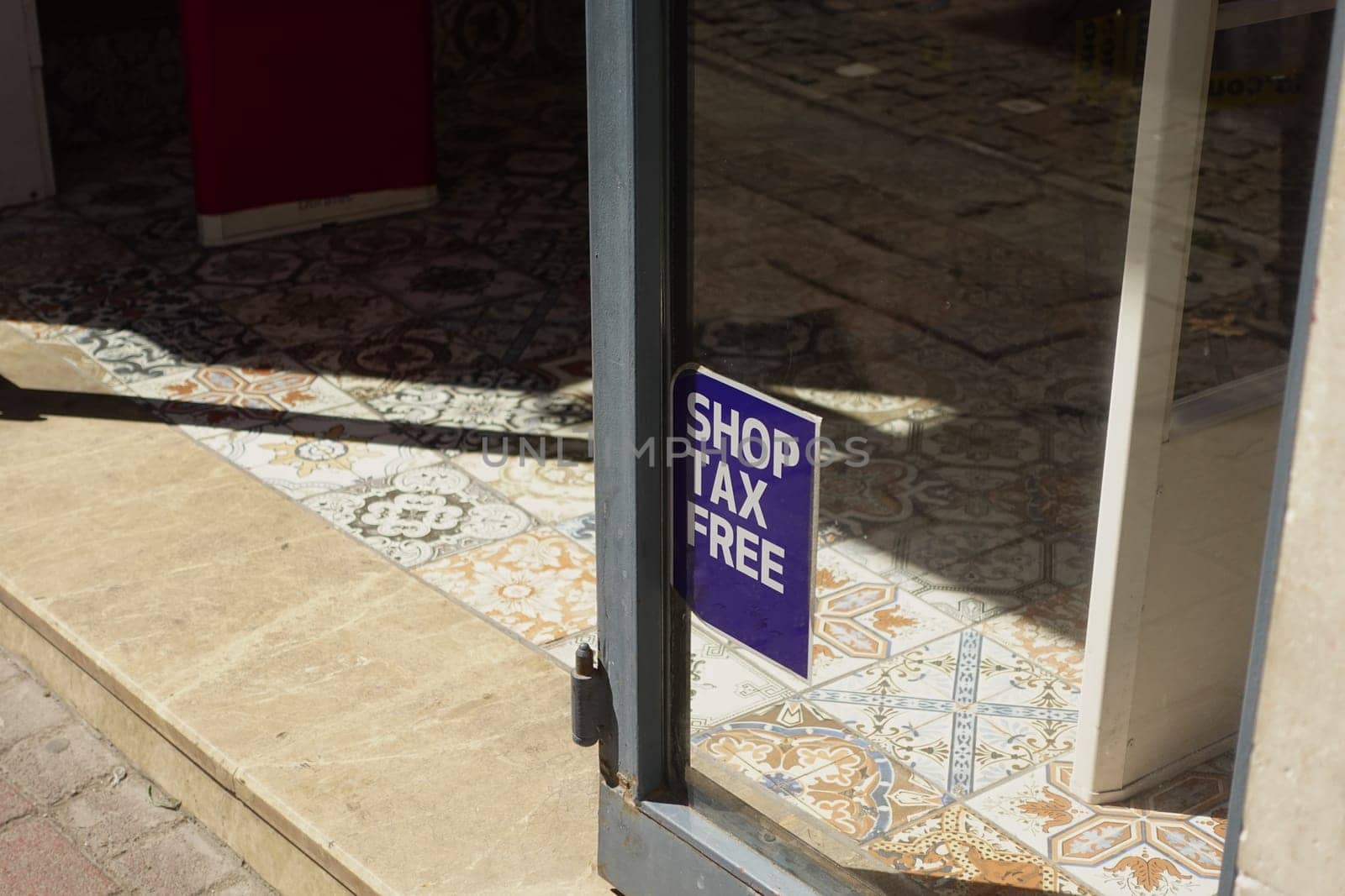 A sign promotes tax-free shopping in a charming retail area.