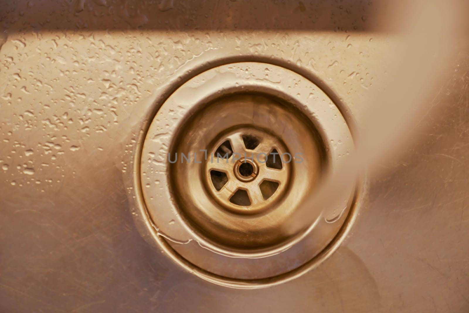 Water flows down a kitchen sink drain during a busy cooking session.