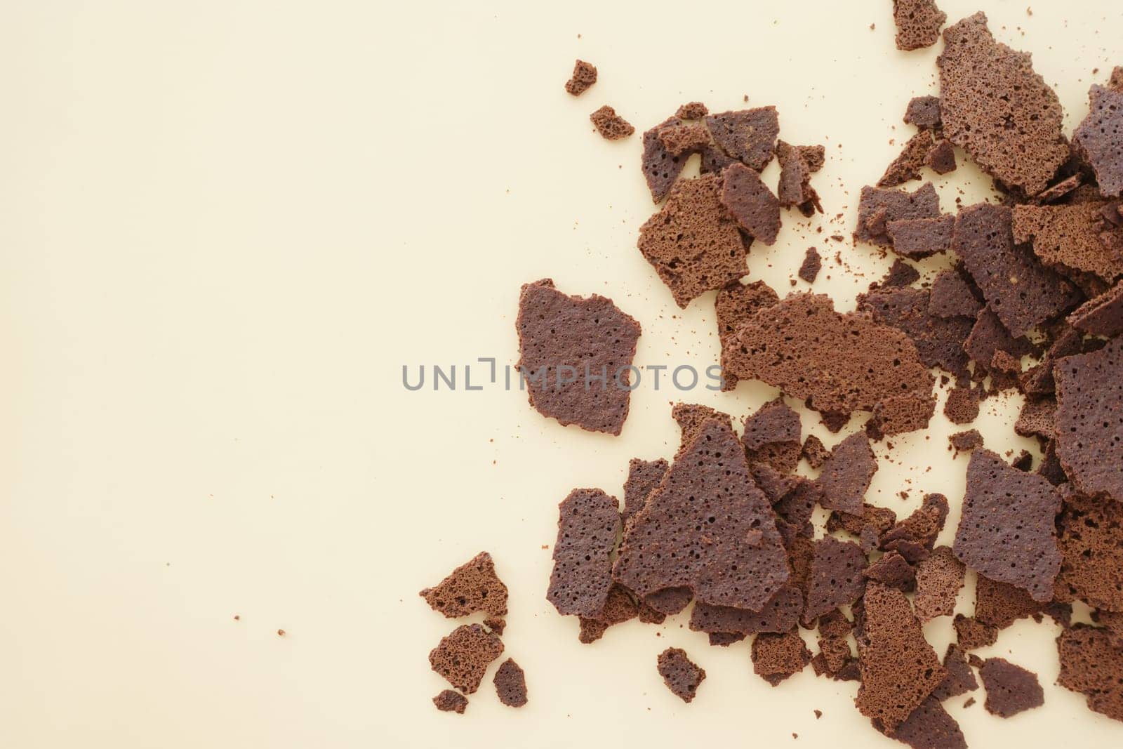 Crumbled chocolate cake pieces create a textured layout on a backdrop.