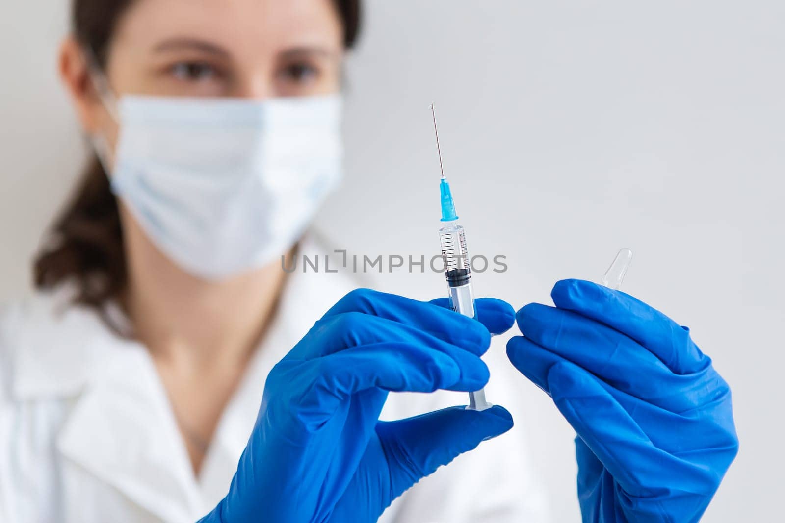 The concept of the new coronavirus COVID-19,2019-nCoV. Syringe with a vaccine in a doctor's hand, close-up