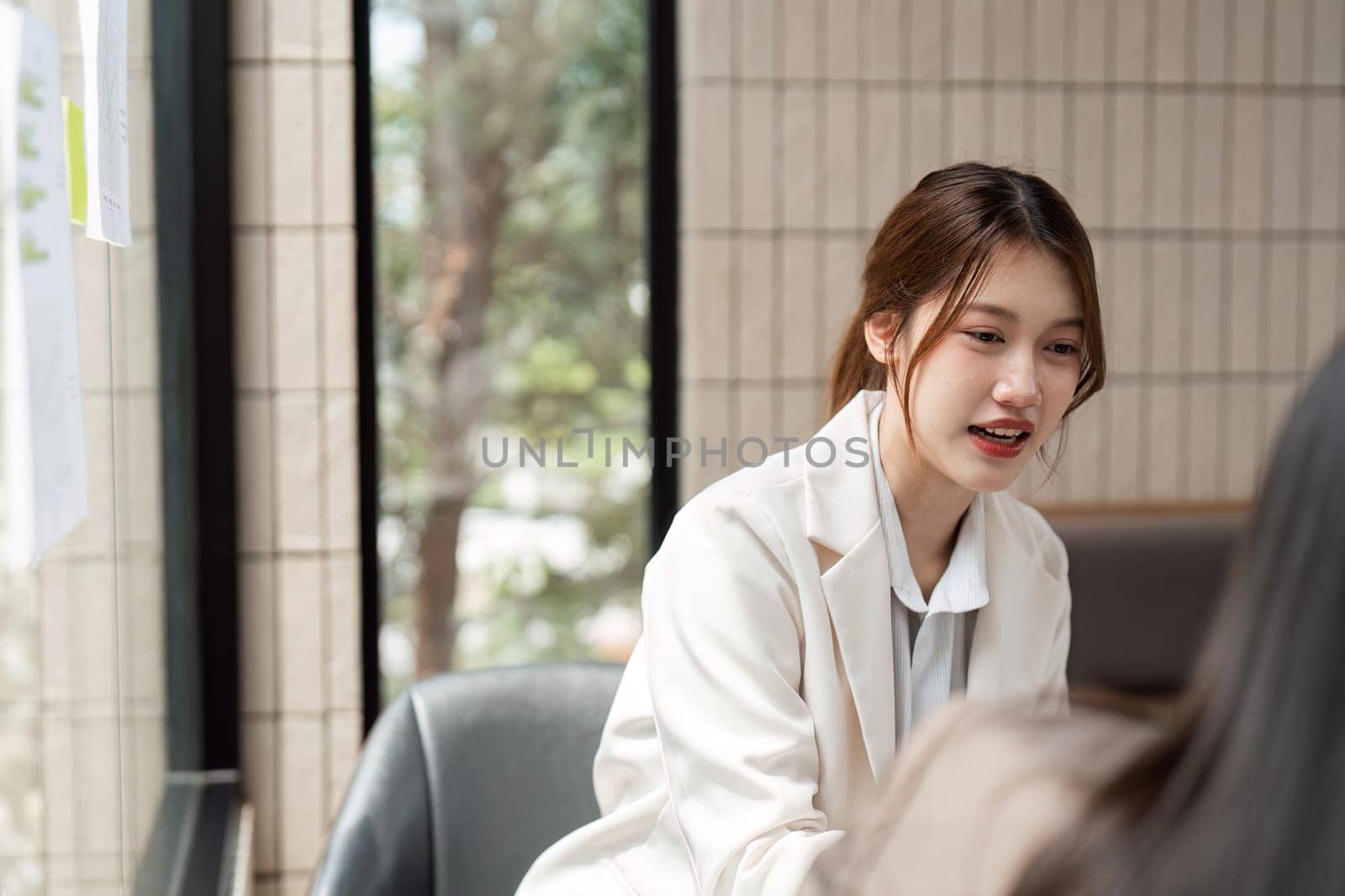 A constructive dialogue focuses on sustainable practices as two women professionals plan their approaches in a bright and inviting office space