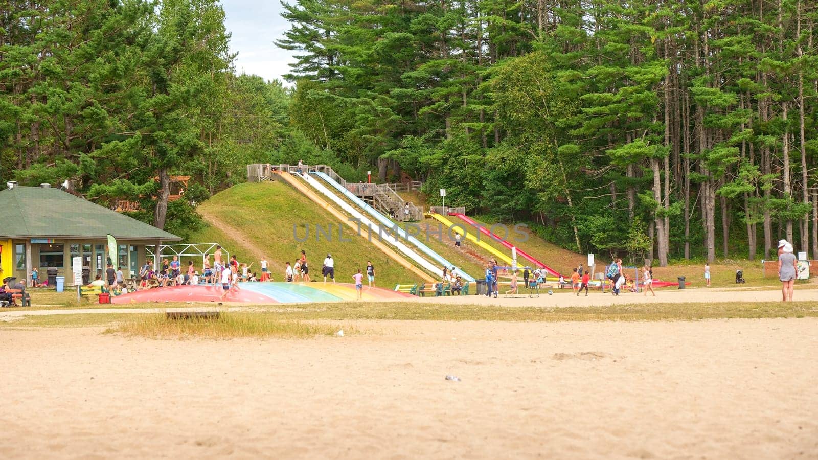 Ottawa, ON Canada - 07.07.2024: Playground equipment on a sandy beach with a forest in the background.