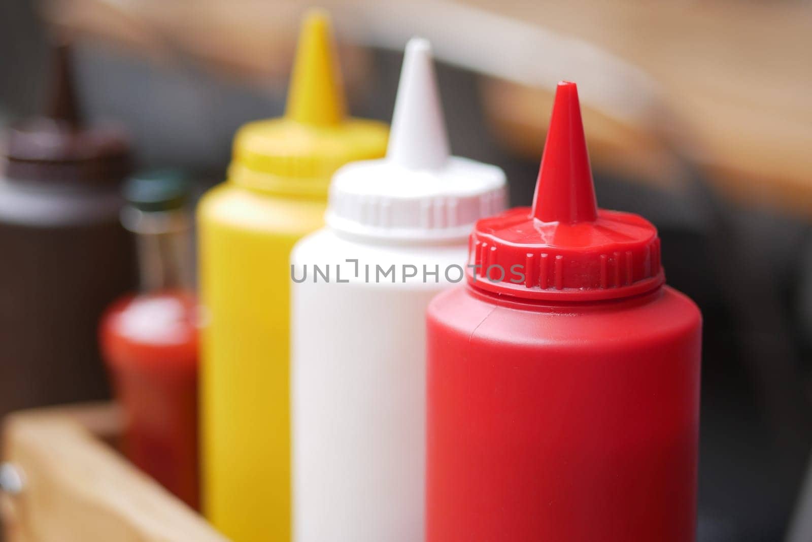 Condiments in various colors are arranged neatly for serving food.