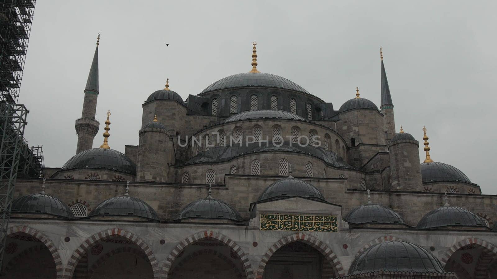 Overcast day view of the Sultan Ahmed Mosque (Blue Mosque) in Istanbul, showcasing its numerous domes, minarets, and stone facade.