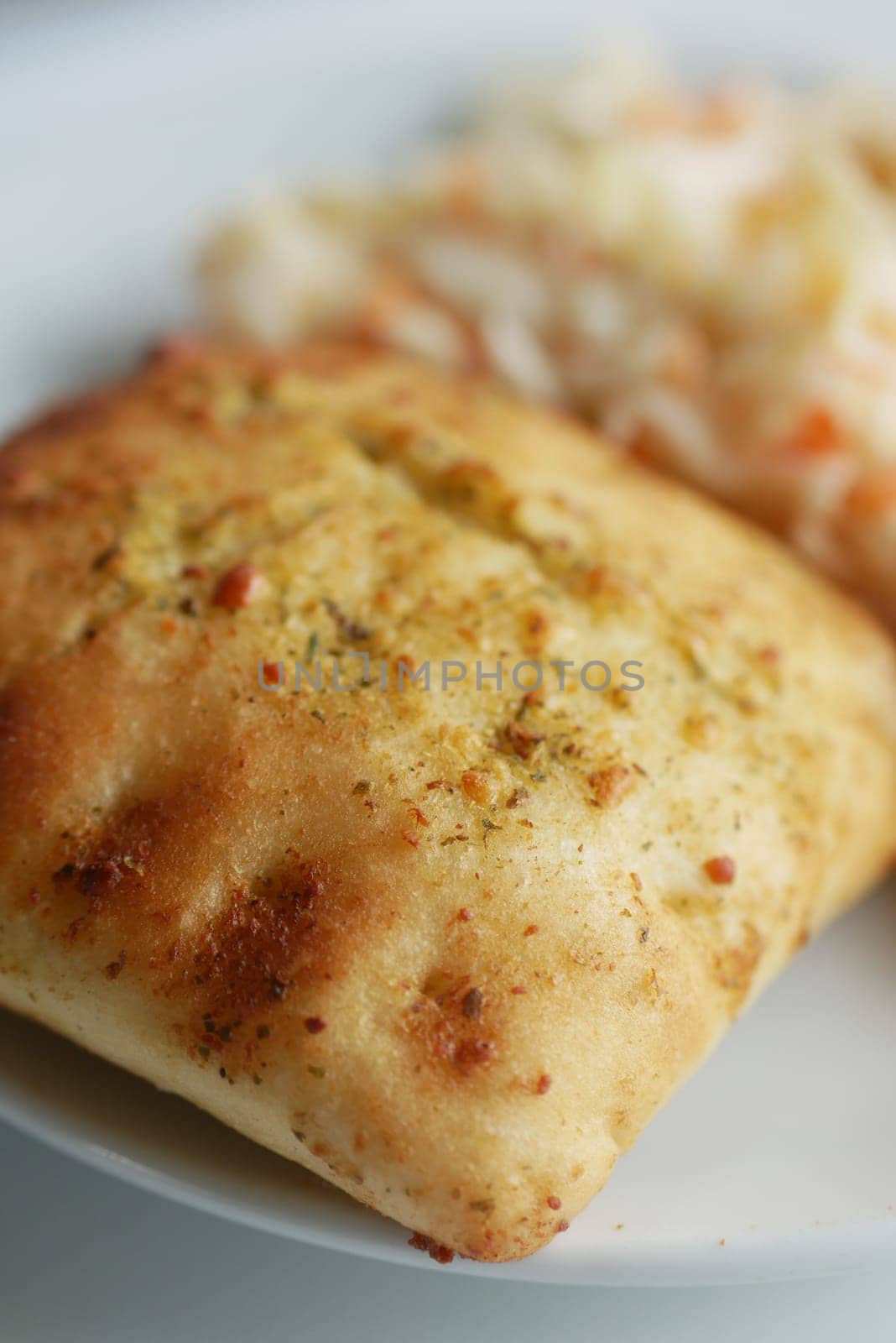Tasty baked item with a crispy texture served alongside fresh coleslaw.