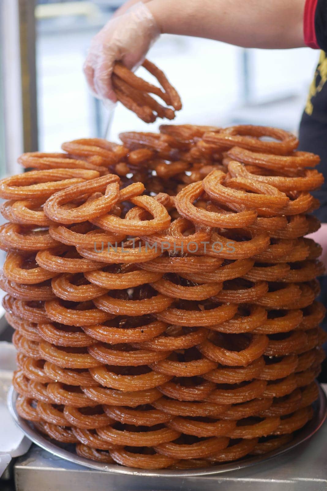 Stacked of Turkish dessert, Tulumba ready for serving in a busy market,