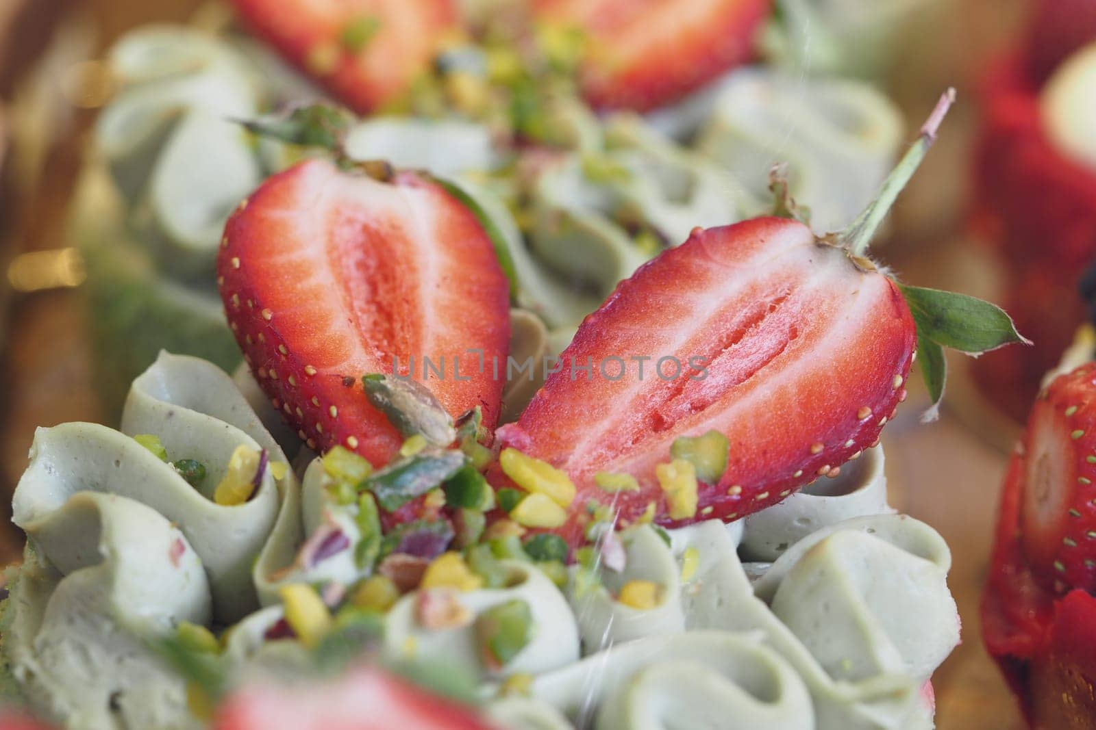 Green tea cupcakes topped with strawberries and crunchy nuts.