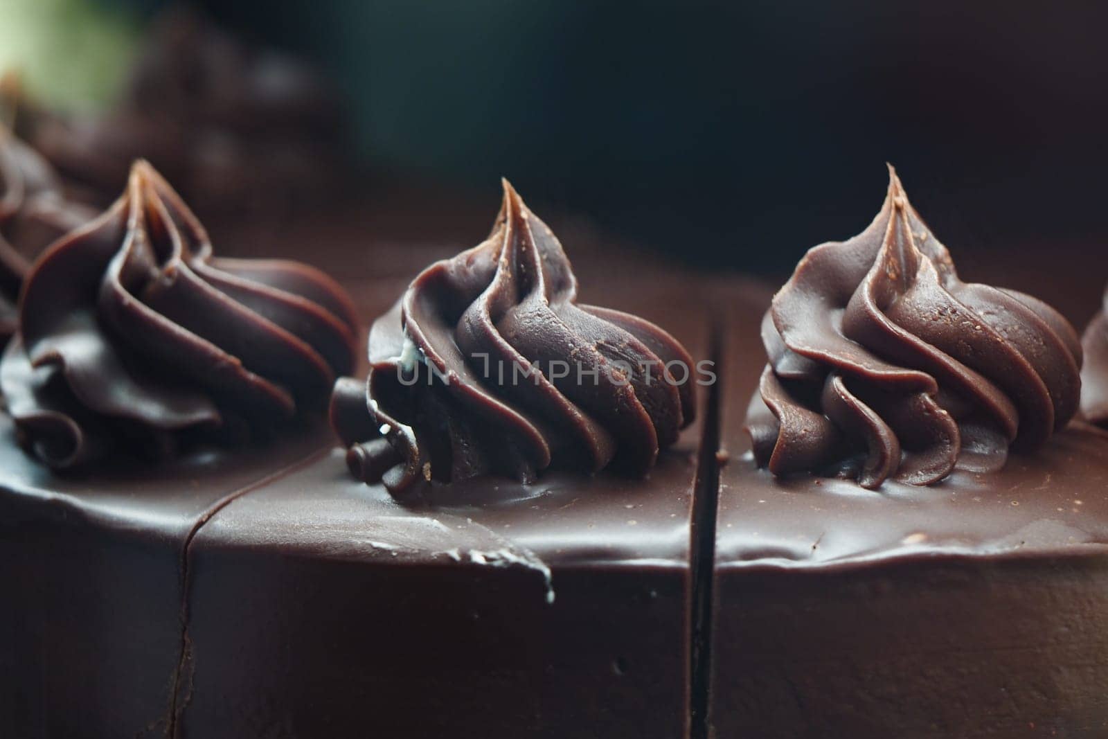 Decadent chocolate cake topped with rich, elegant frosting swirls.