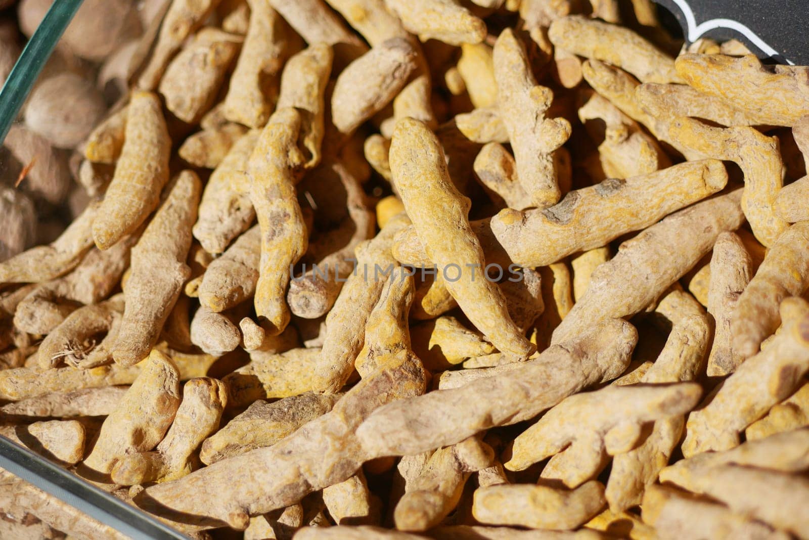 Vibrant turmeric roots are shown in a market, showcasing their earthy texture.
