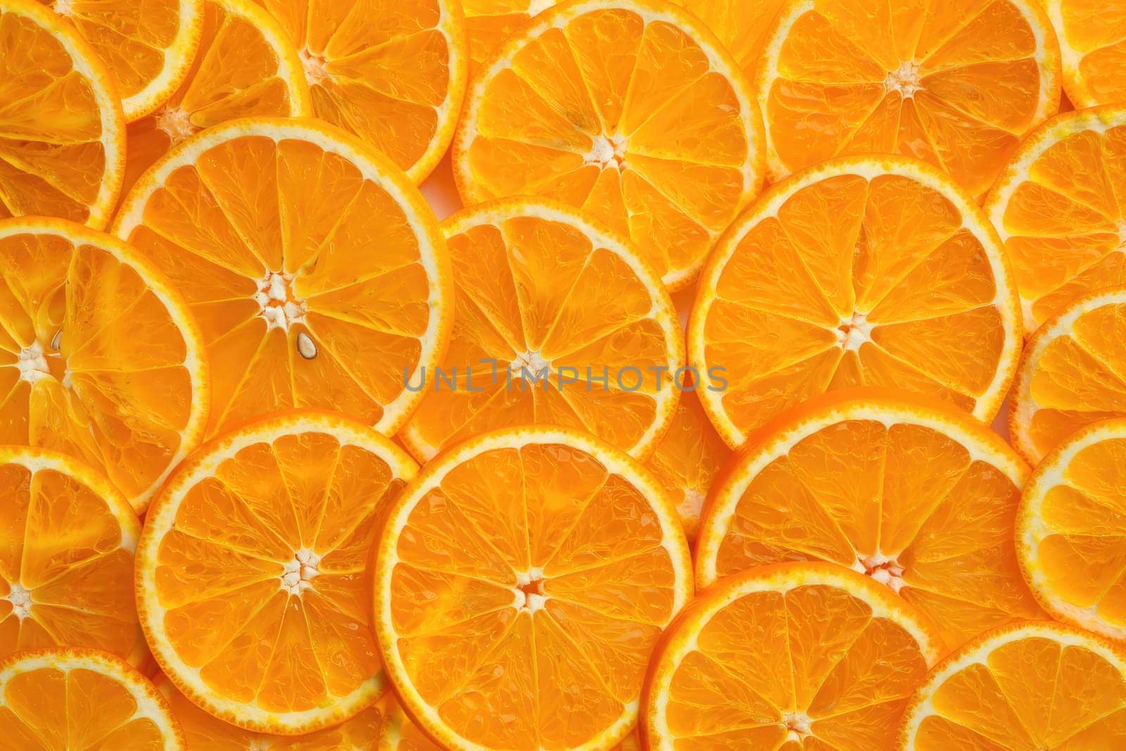 Bright orange slices are neatly arranged in a pattern, showcasing their juicy texture and vibrant color. Perfect for culinary presentations, drinks, or healthy snacks at any time.