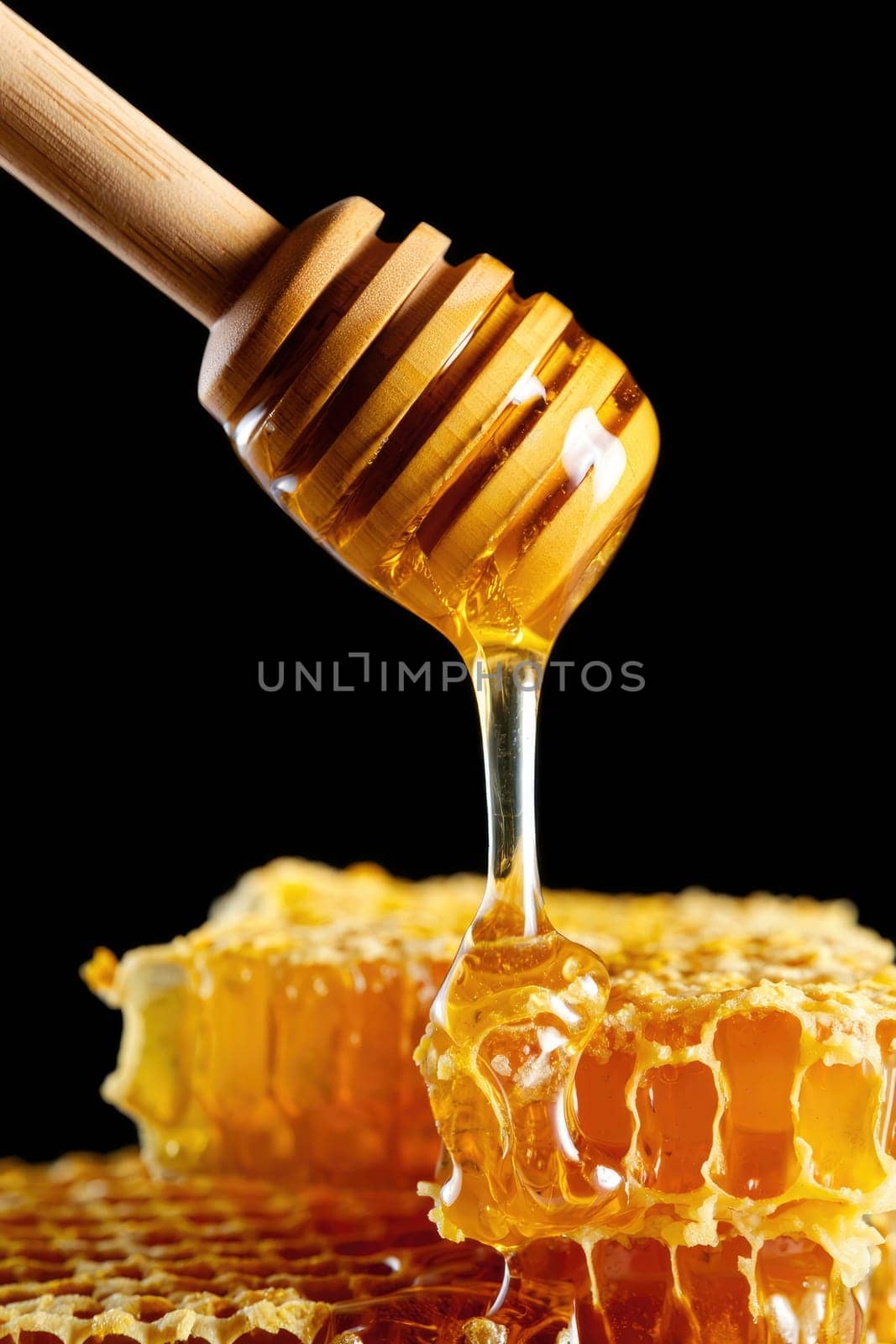 A wooden dipper slowly pulls honey from a honeycomb, revealing a rich amber hue. The sticky liquid glistens under the light, highlighting its smooth texture.
