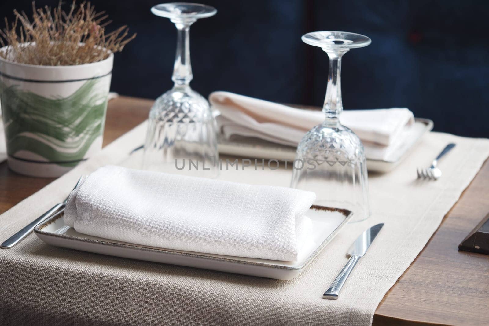 Beautifully arranged table featuring glassware and white linens for dining.