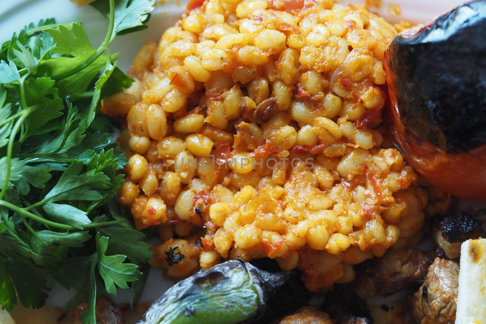 Savor a hearty barley dish topped with grilled vegetables and fresh herbs.