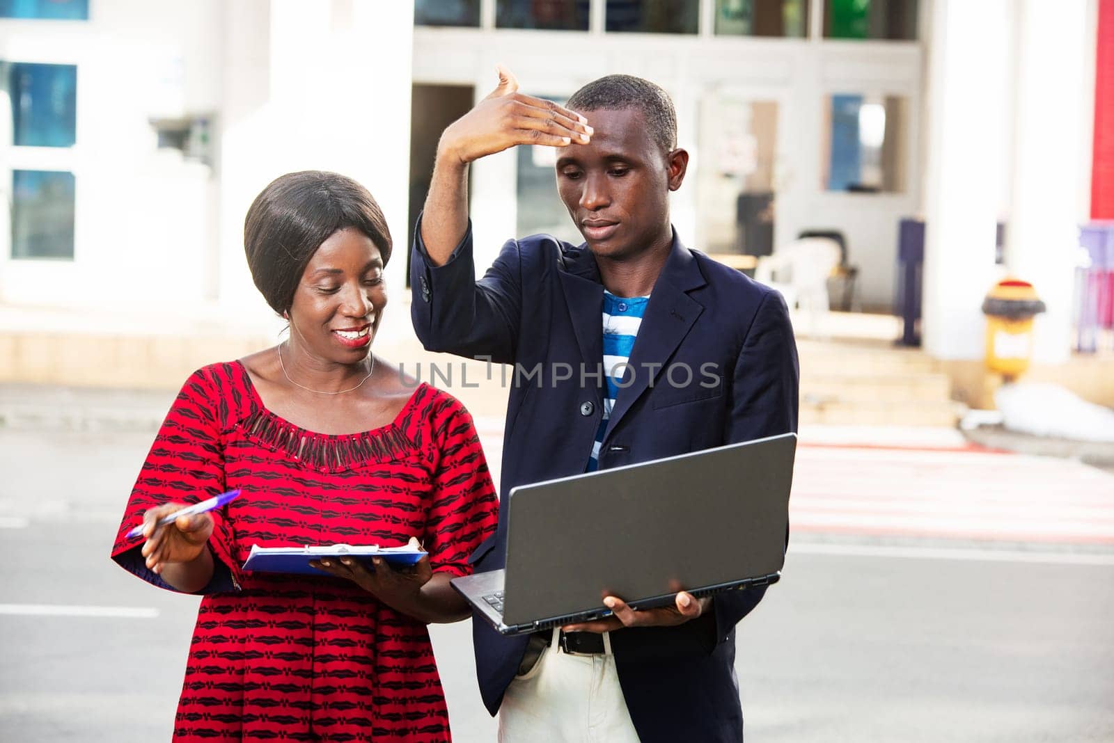 beautiful african adult woman and man working together on a project using a laptop and files outdoors
Business, teamwork and staff concept