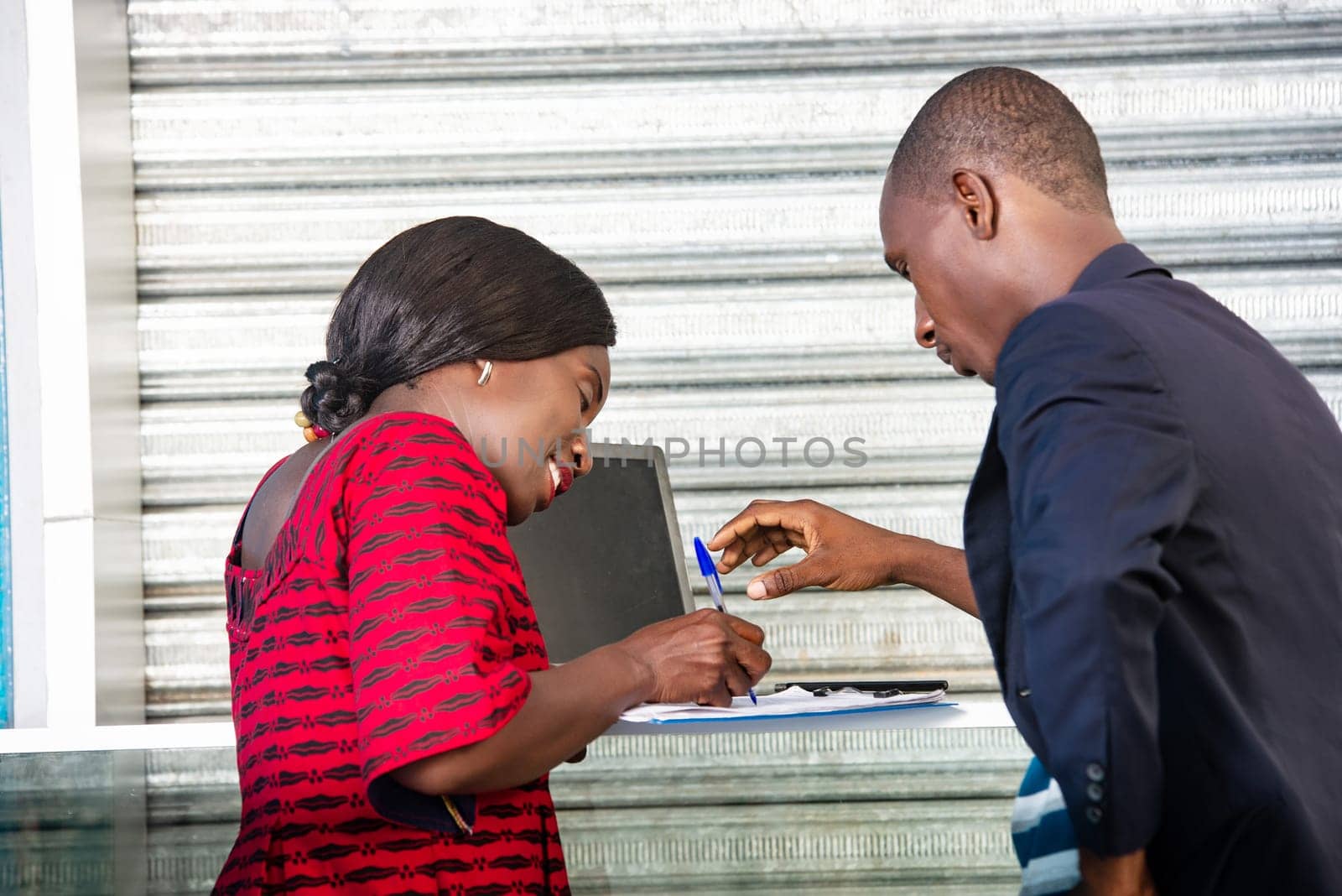 beautiful african adult business woman using a document, signing a contract of employment while smiling