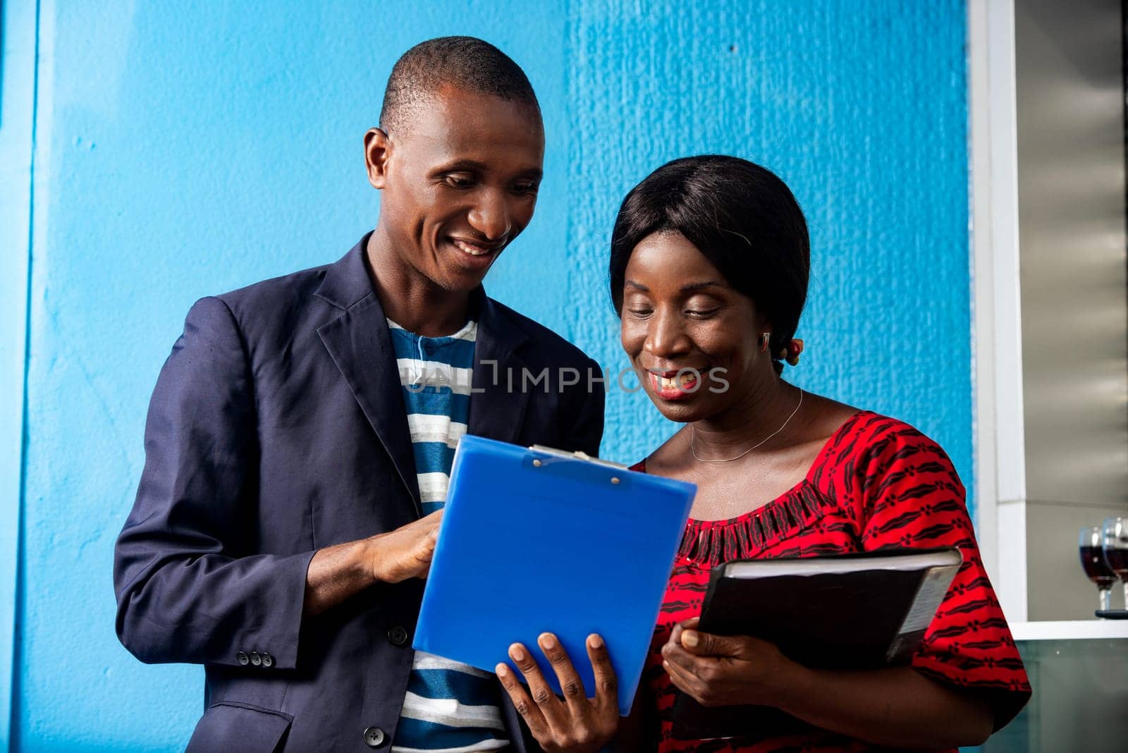 businessman and businesswoman discussing the next project together holding in hand each a document in the street