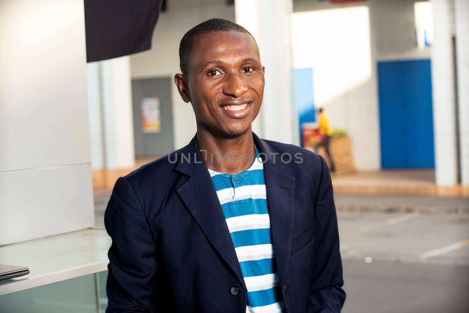 Adult african businessman standing while smiling in the street