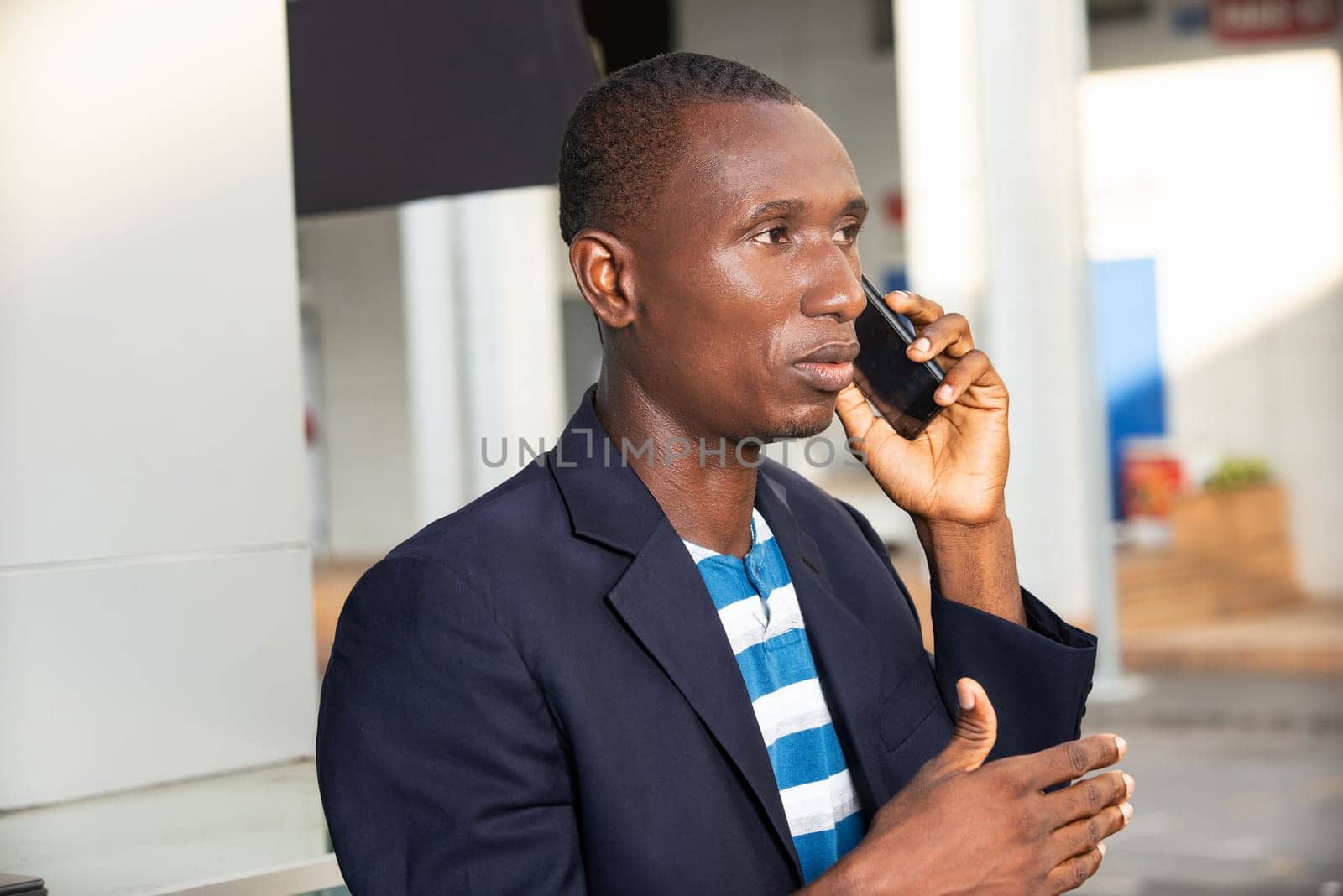 Adult african american businessman talking on a smartphone outdoors in the street