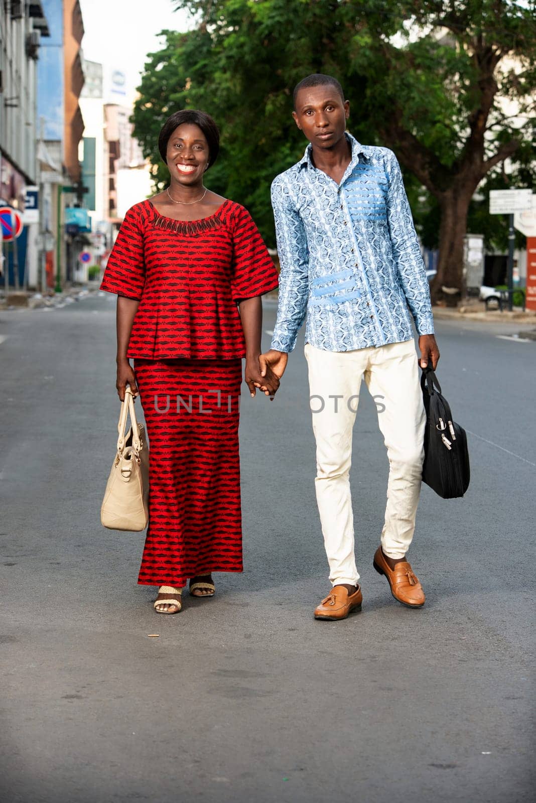 happy couple walking together holding hands outdoors on the street being happy