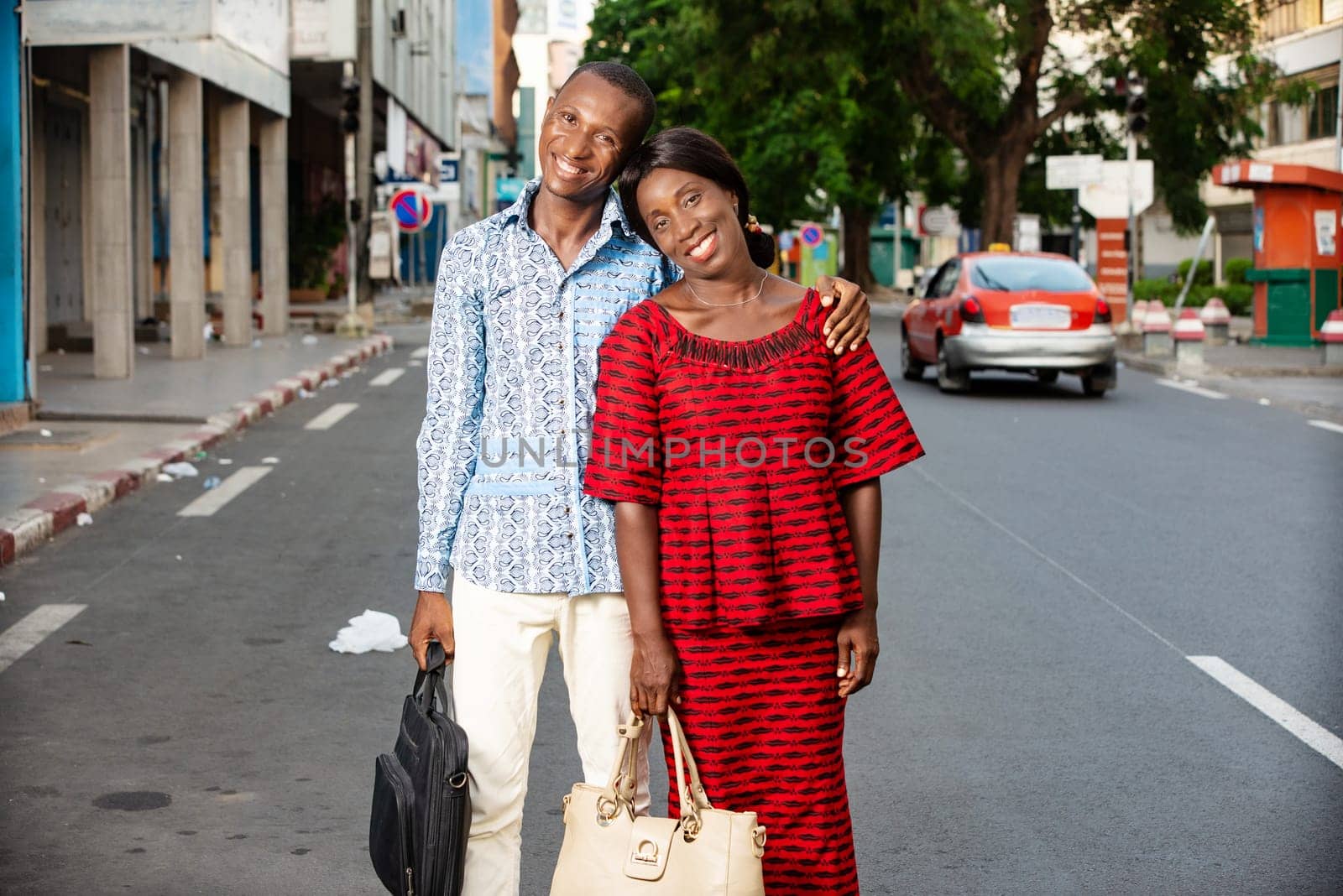 beautiful adult businesswoman dressed in red loincloth walking together with her partner wearing a shirt and jeans on the street being happy