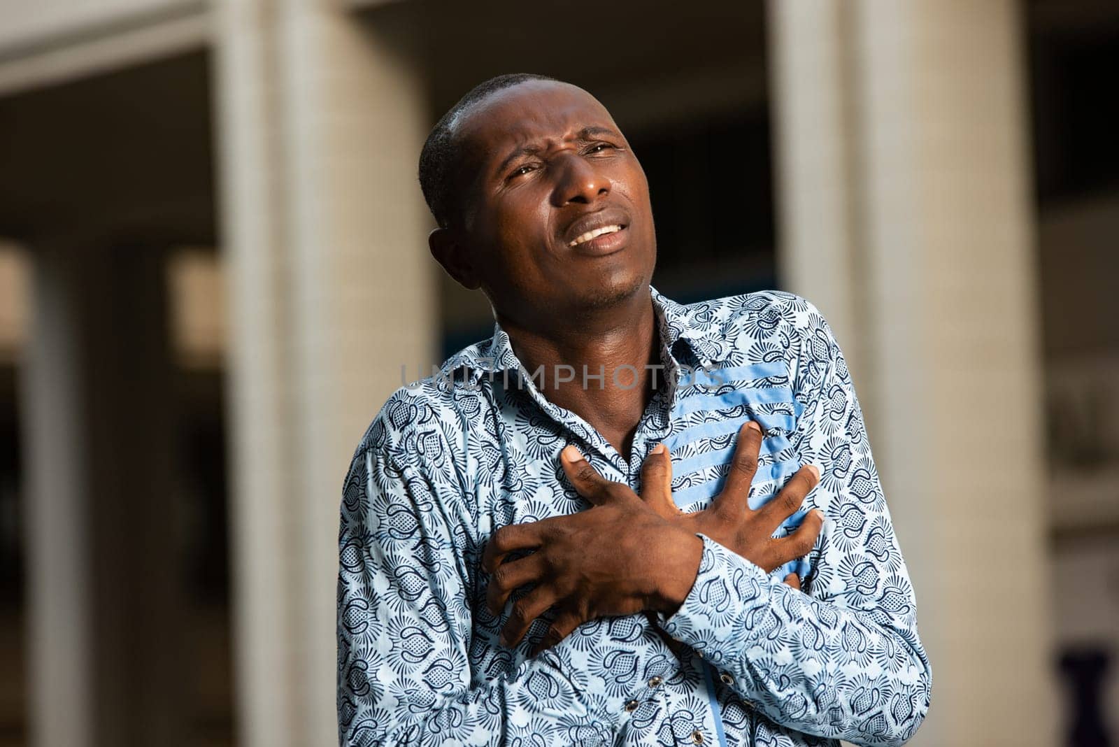 African adult man with health problems and heart pain in the chest